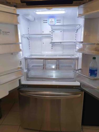 an empty refrigerator with its door open in a kitchen at Otay Studio great patio near Otay Crossing & Airport in Tijuana