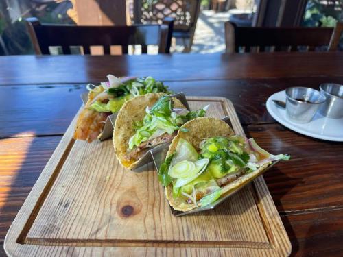 two sandwiches on a wooden tray on a table at Otay Studio great patio near Otay Crossing & Airport in Tijuana