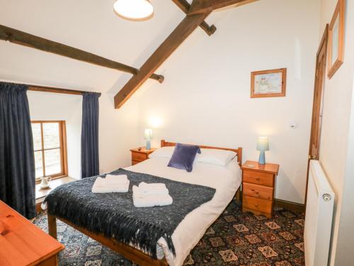 a bedroom with a bed with towels on it at Byre Cottage in Whitby