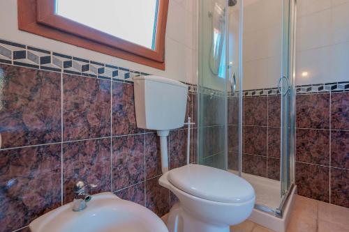 a bathroom with a toilet and a shower and a sink at L'Oasi del Cervo in Arbus