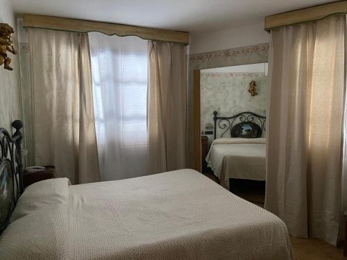 a bedroom with two beds and a mirror at Locanda le Monache in Camaiore