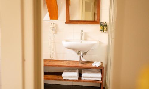 a bathroom with a sink and a mirror and towels at Hotel Golden Key Prague Castle in Prague
