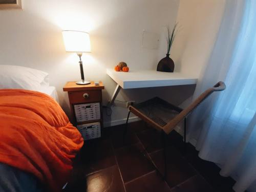 um quarto com uma cama e uma mesa com um candeeiro em Alto de Sarmiento em Tandil