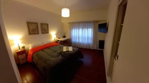 um quarto com uma cama, 2 candeeiros e uma janela em Alto de Sarmiento em Tandil