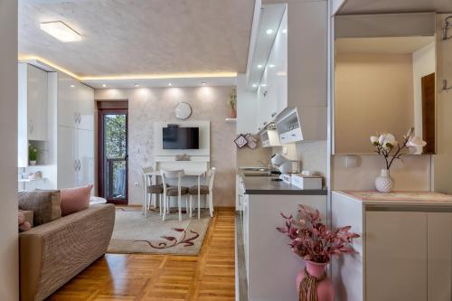 a kitchen and living room with a couch and a table at Apartman Tajena in Zlatibor