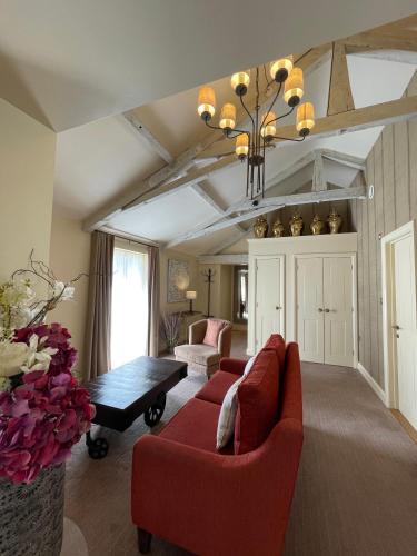 a living room with a red couch and a table at Park Farm Hotel in Norwich
