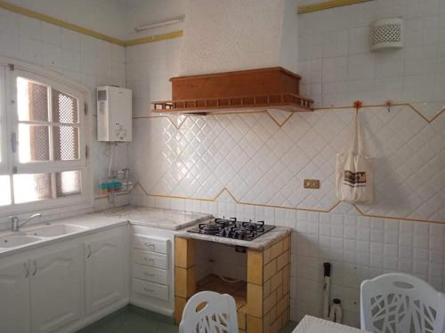 a kitchen with a stove and a sink in it at Villa luxueuse meublée in Sfax