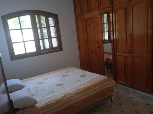 a bedroom with a bed and a window at Villa luxueuse meublée in Sfax