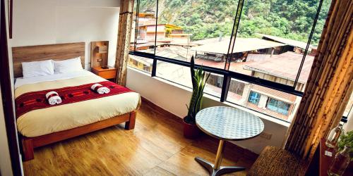 a bedroom with a bed and a large window at Runas Inn Machupicchu in Machu Picchu