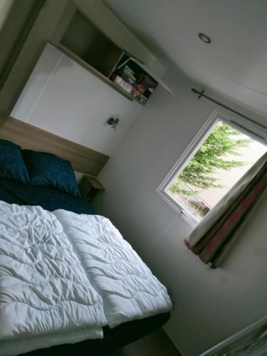 a bedroom with a bed and a window at BJ Chalets - Robbengat 68 - Gezellige chalet op vakantiepark Lauwersoog! Vroege incheck! in Lauwersoog