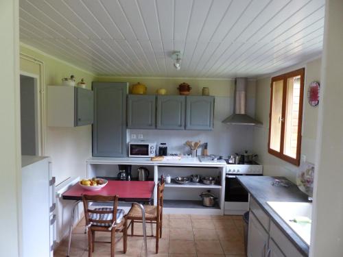 une cuisine avec des placards verts et une table rouge dans l'établissement La Calypso Maison 6 Personnes, à Blangy-sur-Bresle