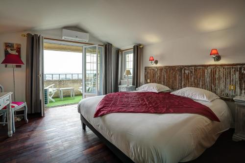 a bedroom with a large bed and a large window at La Chaumière, Demeure d'hôtes in Lauris