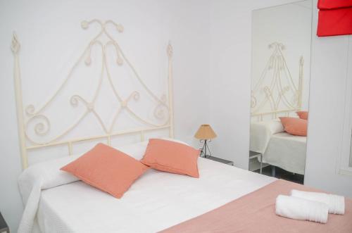 - une chambre avec un lit blanc et deux oreillers orange dans l'établissement Casa rural Aldea, à La Alameda de Cervera