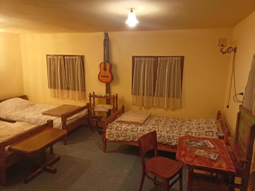een kamer met twee bedden en een gitaar erin bij Brvnara Ljubičica in Kremna