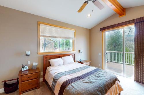 ein Schlafzimmer mit einem Bett und einem großen Fenster in der Unterkunft Murray Lake Retreat in Bass Lake