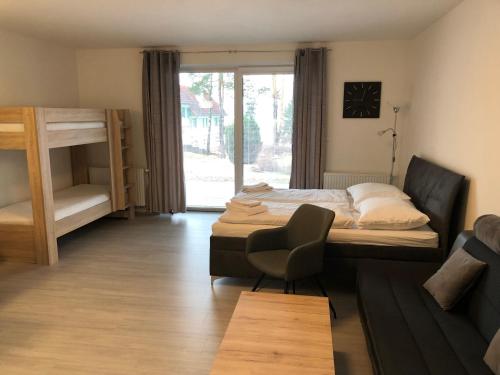 a bedroom with two bunk beds and a chair at Riviera Lipno Provence in Lipno nad Vltavou