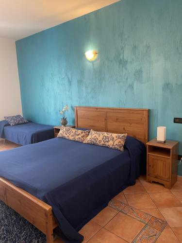 a bedroom with two beds and a blue wall at Colle Uliveto in Vico Equense