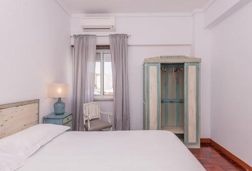 1 dormitorio con 1 cama, 1 silla y 1 ventana en Cozy 3 bedroom apartment in front of the subway, en Lisboa