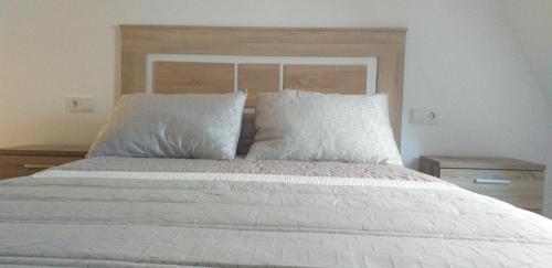 a bedroom with a large white bed with two pillows at APARTAMENTOS DON MANUEL D in Cee