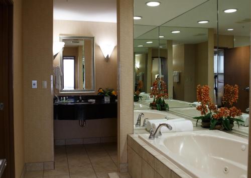 a large bathroom with two sinks and a large mirror at Holiday Inn Battle Creek, an IHG Hotel in Battle Creek