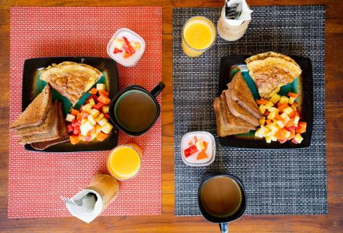 a table with two plates of food and two cups of coffee at Antema Lodge Secteur Tamarindo, piscine, yoga, gym, jungle et paix in Tamarindo