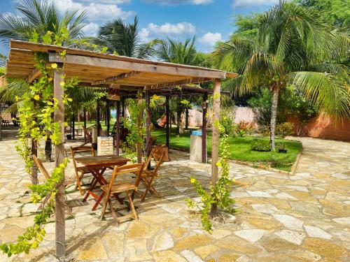 a wooden table and chairs under a pavilion at Pousada Carmela in Icapuí