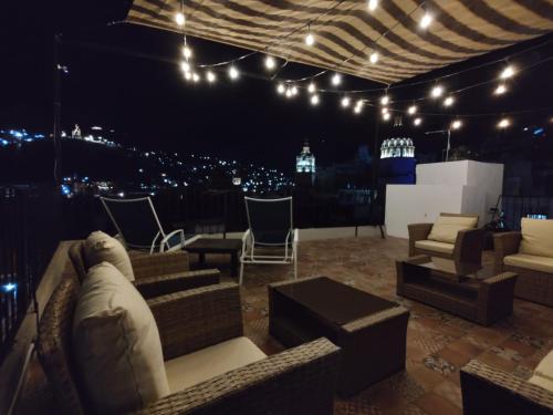 a living room with couches and chairs and lights at Terrazas de la Alameda - Panoramic Aparthotel by Lunian in Guanajuato