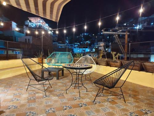 a patio with a table and chairs on a roof at Terrazas de la Alameda - Panoramic Aparthotel by Lunian in Guanajuato