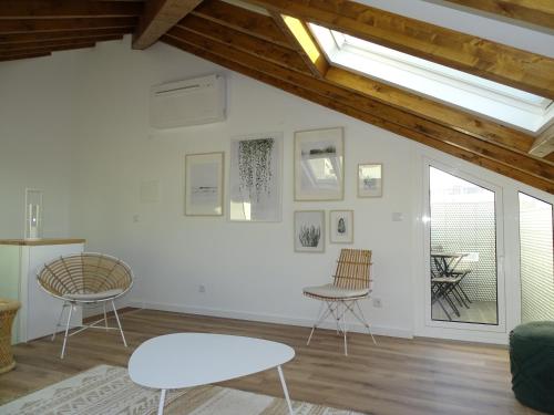 a living room with two chairs and a table at Casa do Largo in Nazaré