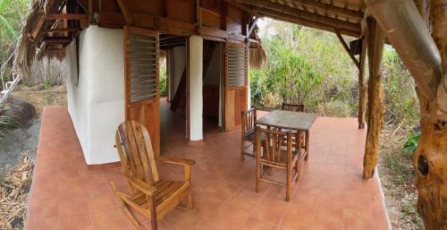 a porch of a house with a table and chairs at El Zopilote in Balgue