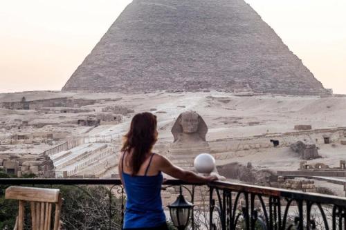 a woman standing in front of the pyramid at Pyramids View Inn in Cairo