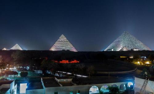 a group of pyramids lit up at night at Pyramids View Inn in Cairo
