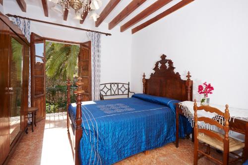 1 dormitorio con 1 cama con colcha azul en Hostal Miramar en Deia