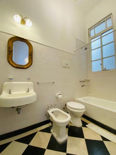a bathroom with a toilet and a sink and a tub at Hotel Chemin in Buenos Aires