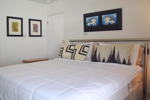 a bedroom with a large white bed with pillows at West Racquet Club Art Room in Palm Springs
