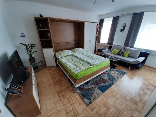 a bedroom with a bed and a couch at City Apartmentstudio mit Tiefgarage free parking in Graz