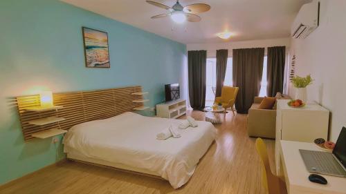 a bedroom with a bed and a desk with a laptop at STAY Eden Beach Studio in Limassol