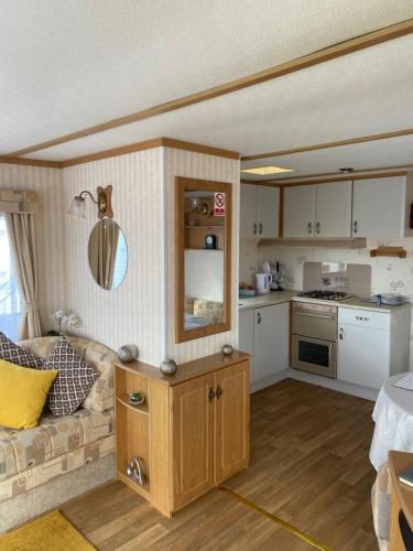 a living room with a couch and a kitchen at L&g FAMILY HOLIDAYS 8 BERTH CORAL BEACH JOHN FAMILYS ONLY AND LEAD PERSON MUST BE OVER 30 in Ingoldmells