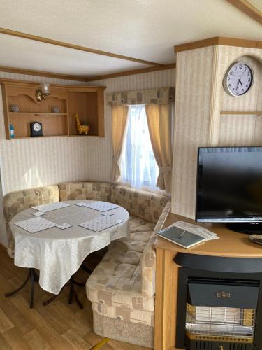 a living room with a couch and a table at L&g FAMILY HOLIDAYS 8 BERTH CORAL BEACH JOHN FAMILYS ONLY AND LEAD PERSON MUST BE OVER 30 in Ingoldmells