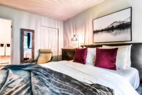 a bedroom with a large white bed with purple pillows at Hauts-bois Ski Inout 2brs Wpool Access 193-1 in Mont-Tremblant
