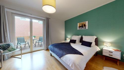 um quarto com uma cama grande e uma parede verde em Le Nid Cosy + 1 Garage em Colmar