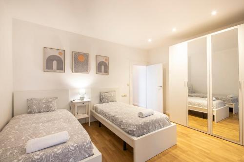 1 dormitorio con 2 camas y espejo en Spacious Central Old Town Apartment en San Sebastián