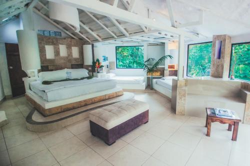 1 dormitorio grande con 2 camas y sofá en Kashama Eco Resort & Spa, en Santo Domingo de los Colorados