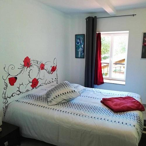 a bedroom with a bed with red flowers on it at Auberge du pèlerin in Saint-Vincent