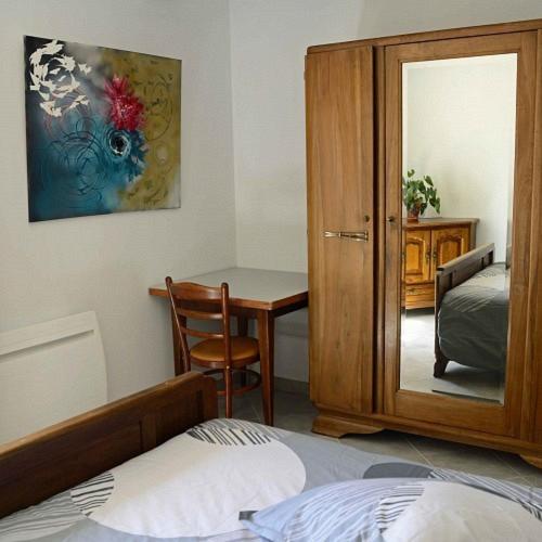 une chambre avec un lit, une table et un miroir dans l'établissement Auberge du pèlerin, à Saint-Vincent