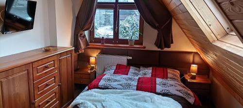 a small bedroom with a bed and a window at Apartament Twój Giewont Zakopane in Kościelisko