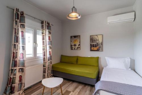um pequeno quarto com um sofá verde e uma janela em Veranda Guest House em Litochoro