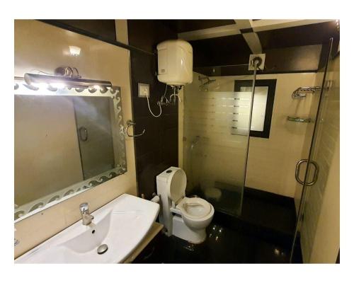 Drive Inn Dhanaulti في دانولتي: حمام مع مرحاض ومغسلة ودش