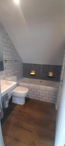a bathroom with a sink and a toilet and a tub at Little Orchard House in Salcombe