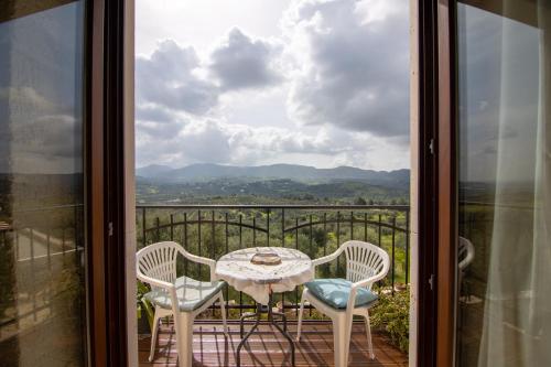 a table and chairs on a balcony with a view at Kritamos Villa & Apartments in Kamilari
